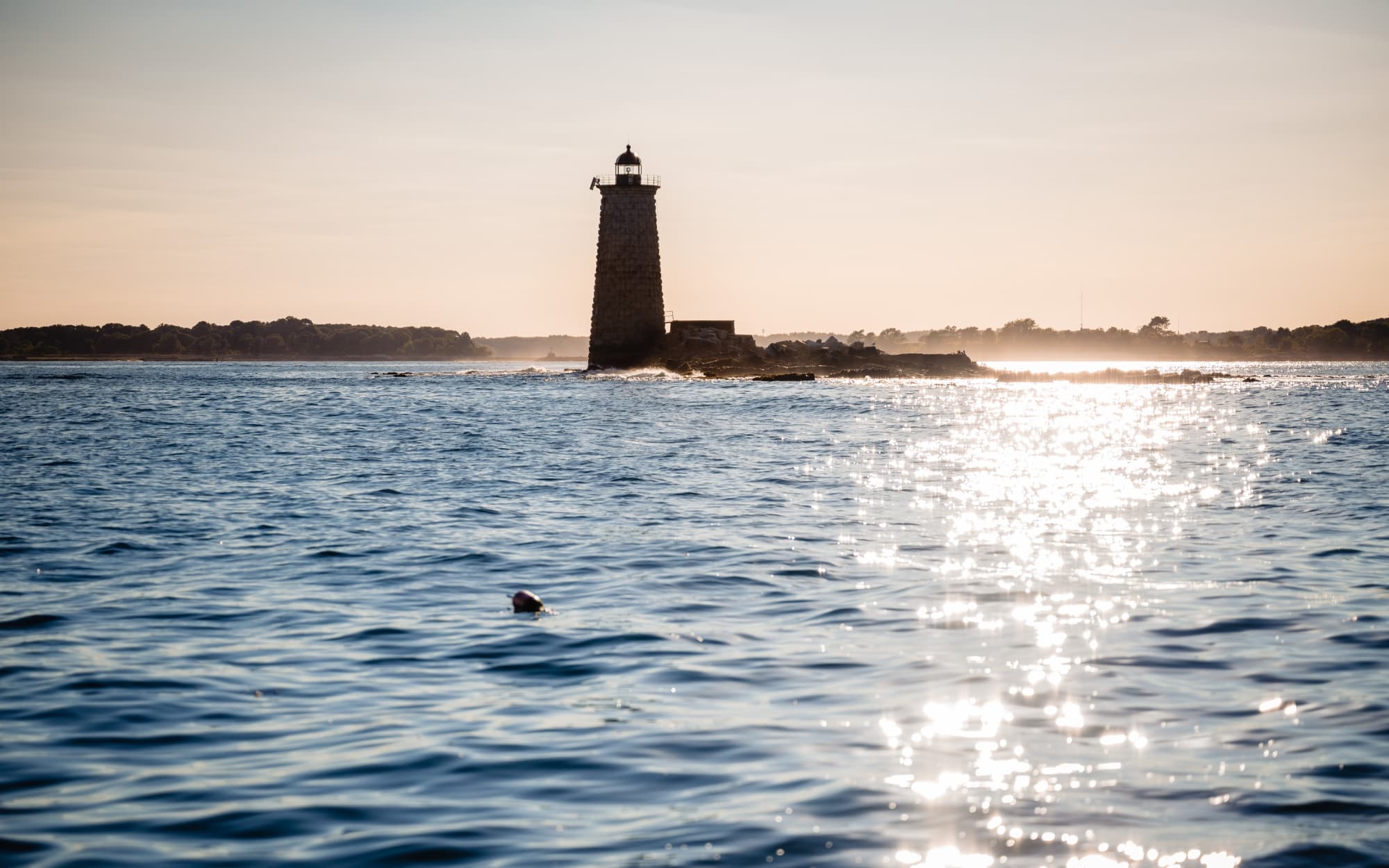 An ocean lighthouse off of Maine an New Hampshire waters during sunset.
